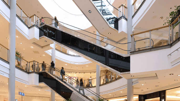 Inside of a shopping centre, escalators taking customers between floors.